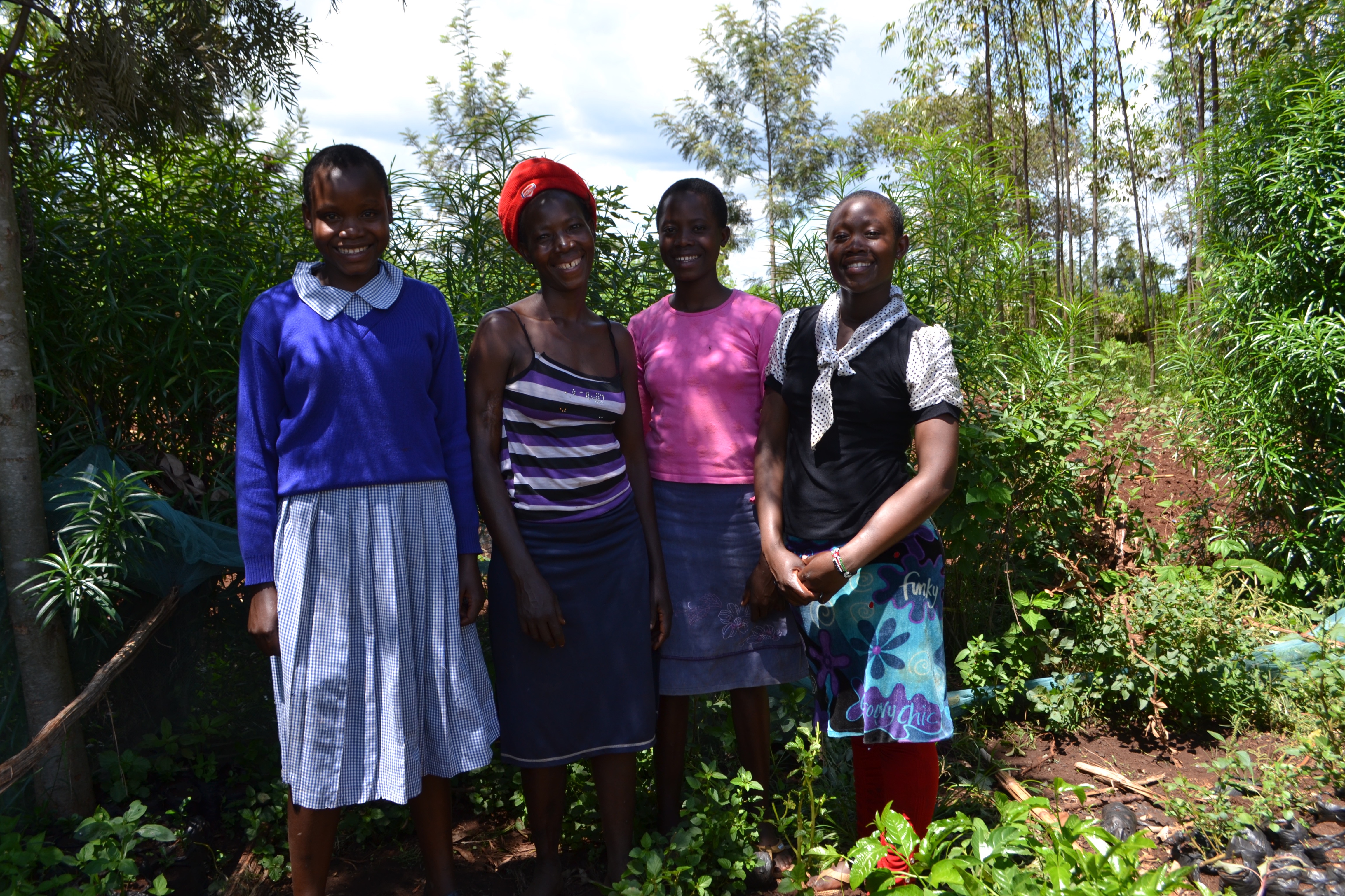 Four people standing close by in forested area
